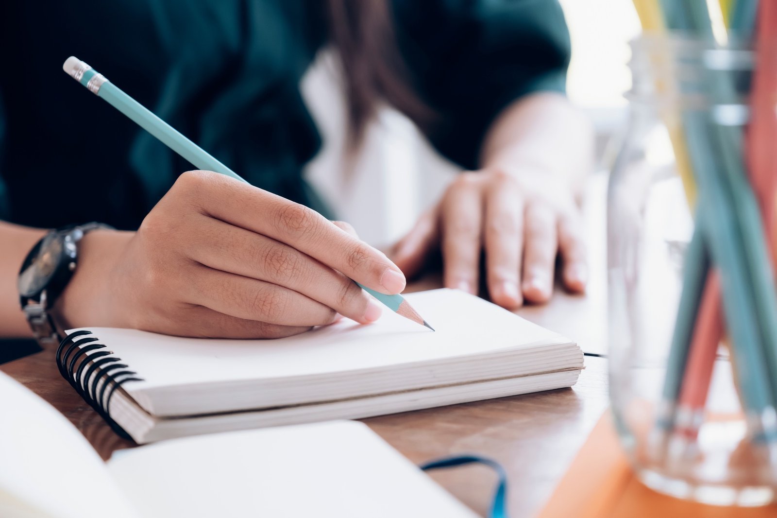 Female hand writing notebook.
